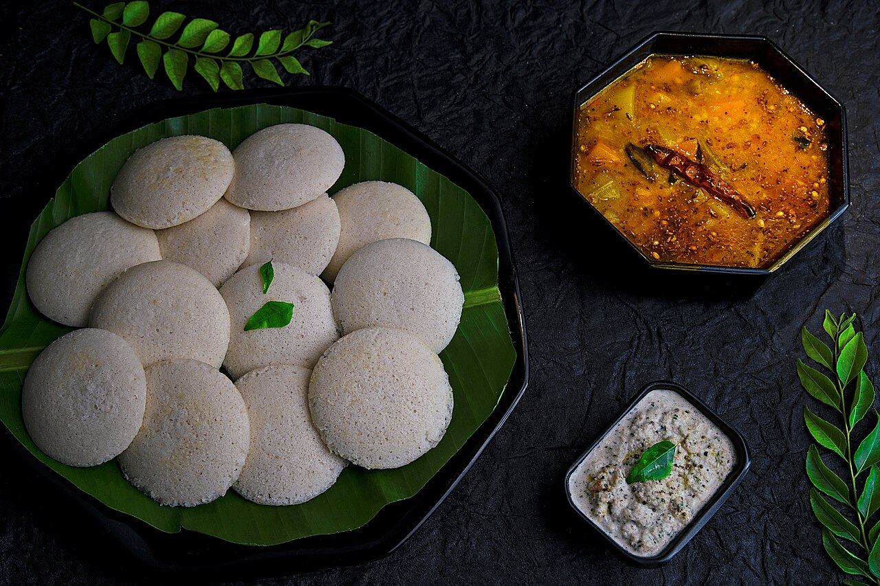 Soft idlis on a banana leaf with sambar and chutney